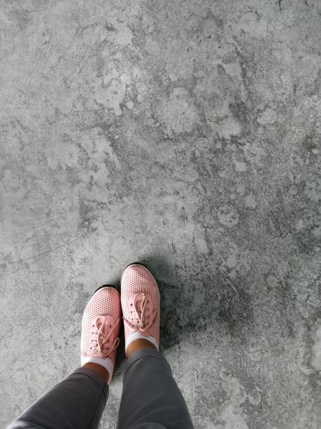 top view old brown tone leather shoe detail on grunge concrete floor, Selfie feet wearing sneakers shoes on floor stock photo