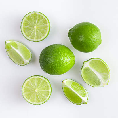 Set of fresh whole and cut lime and slices isolated on white background. From top view