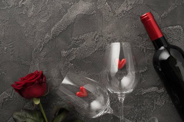 Top view photo of st valentine's day decorations two wineglasses with small hearts red rose and wine bottle on isolated textured dark grey concrete background with blank space Top view photo of st valentine's day decorations two wineglasses with small hearts red rose and wine bottle on isolated textured dark grey concrete background with blank space happy birthday wine bottle stock pictures, royalty-free photos & images