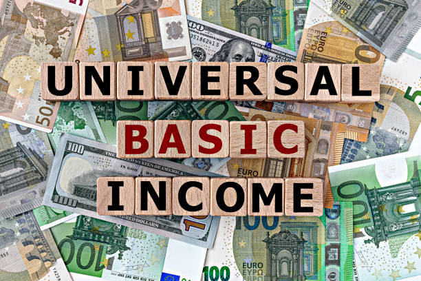 topview photo on universal basic income theme. wooden cubes with the inscription "universal basic income", on the background of dollar and euro bills stock photo