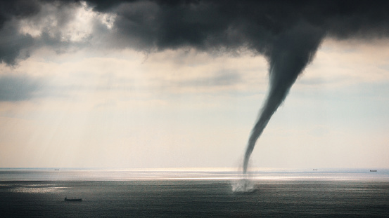 Tornado Sea view horizontal image with cargo ship near tornado. Nature power concept. Climate change. Weather illustration. Adventure travel conceptual photography.