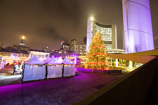 Toronto, Ontario, Canada - December 14, 2018:  The Toronto City Hall and adjacent Nathan Phillips Square are decorated for the Christmas season.  Along with the impressive Christmas displays are vendors, ice skating, entertainment and food.  This has become an annual Christmas event in the city.