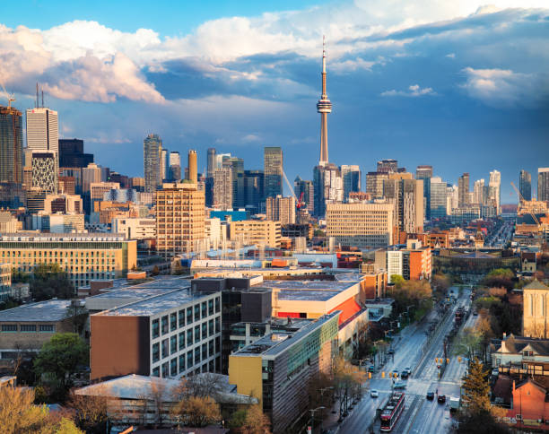 Toronto financial district and Spadina skyline on a partially cloudy Springtime evening Toronto financial district and Spadina avenue skyline on a partially cloudy Springtime evening after a rain stor, lit by sunset. university of toronto stock pictures, royalty-free photos & images