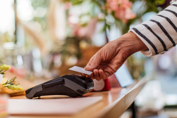 A touch of a card is all that is needed Unrecognizable person making a contactless credit card payment at the flower shop contactless payment stock pictures, royalty-free photos & images