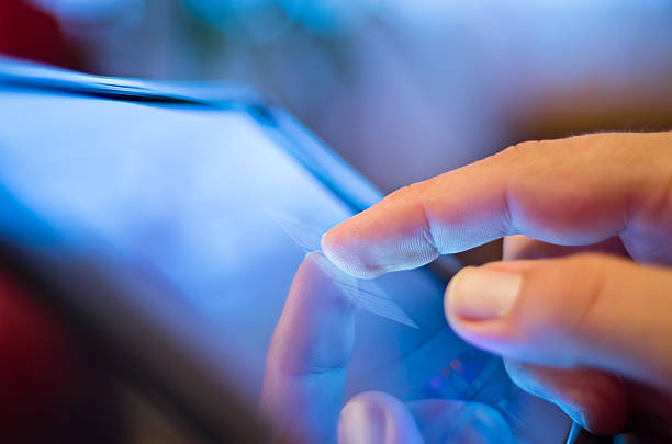 touching screen on tablet-pc closeup of finger touching screen  on tablet-pc with shallow depth of field touch screen stock pictures, royalty-free photos & images