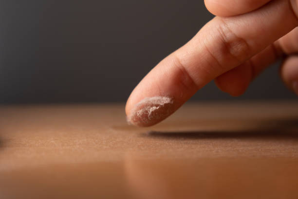 Touching the dust on a surface of furniture with finger stock photo