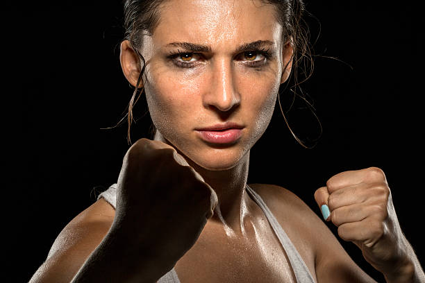 Tough chick powerful strong fighter boxer MMA piecing intense eyes stock photo