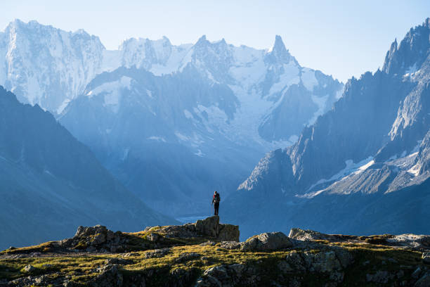 Tour of Mont Blanc view A woman looking at the beautufil mountaoins of Chamonix. alpine climate stock pictures, royalty-free photos & images