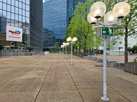 The Tour Total building now serves as headquarters for TotalEnergies. The  office building in La Défense with a height of 187 m was planned by WZMH Architects, Roger Saubot and realized between 182 and 1985. The image shows the building partially and was captured during springtime.