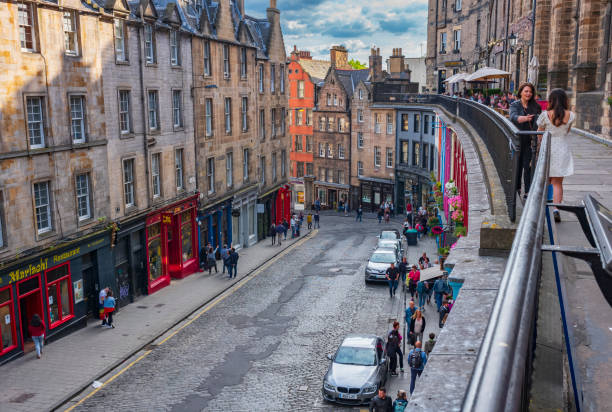 Tourist explore the West Bow street that is lined with retail stores, restaurants, night clubs and pubs. West Bow begins Grassmarket and ends at the George IV Bridge. stock photo