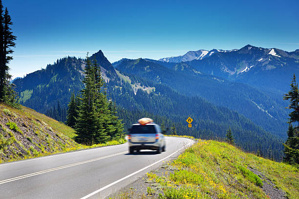 Tourist Road Trip at Olympic National Park, Washington, USA Tourist driving on the mountain road of Olympic National Park in Washington State, USA. The park features glacial snow capped mountain peaks and the scenic coastline of the Pacific Ocean. The scenic roadway around the park is a popular scenic drive. Photographed in horizontal format. olympic national park stock pictures, royalty-free photos & images