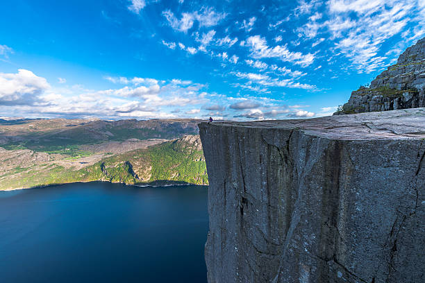 Tourist sitting at Famous Pulpit Rock edge in Norway stock photo