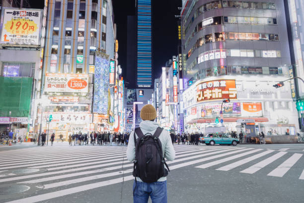 A tourist standing on urban street in Kabukicho, Shinjyuku at night An asian male tourist standing on the night street in Kabukicho, which is one of the most famous entertainment and nightlife districts in Japan. japan  tourism stock pictures, royalty-free photos & images