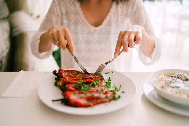 toeristische vrouw eten in restaurant - vegan keto stockfoto's en -beelden