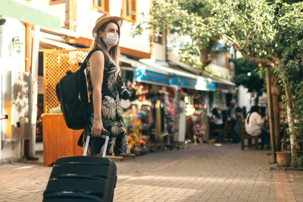 Tourist woman wearing protective face mask and  exploring new place Tourist woman wearing protective face mask and  exploring new place tourism stock pictures, royalty-free photos & images