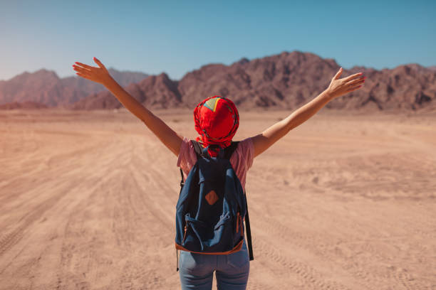 Tourist woman with backpack wearing scarf on head. Happy traveler admiring Sinai Desert and mountains Tourist woman with backpack wearing scarf on head. Happy traveler admiring Sinai Desert and mountains with raised hands. Summer vacation hot arab women stock pictures, royalty-free photos & images