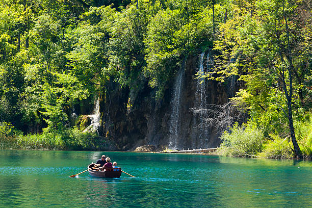 Tourists on a boat to enjoy the views of waterfall stock photo