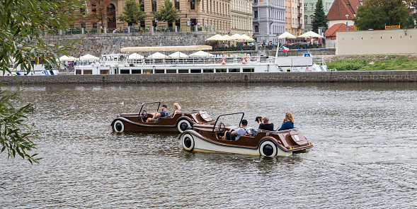 Tourists on pedal boats glide on the Vltava river, Prague