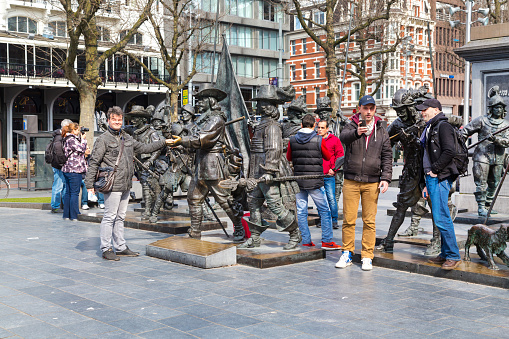 Amsterdam, Netherlands - March 31, 2016: Tourists posing for photo near Night Watch by Rembrandt in Rembrandtplein, Amsterdam, Netherlands
