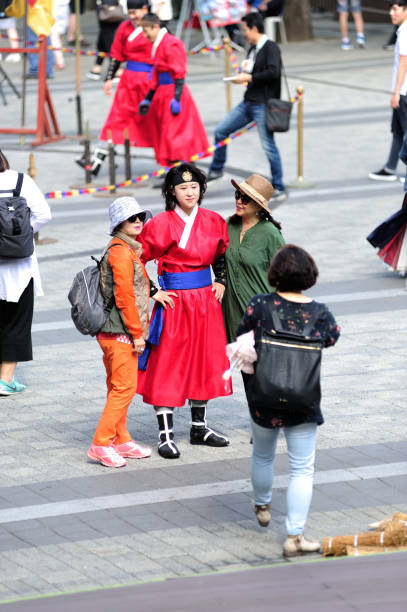 Tourists take photos with korean woman wearing traditional clothes at n seoul tower in Seoul City, South Korea. stock photo