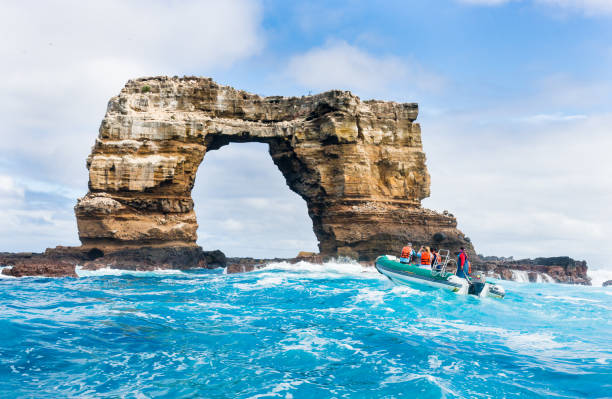 Tourists Taking Pictures of Darwin Arch in Galapagos Islands stock photo