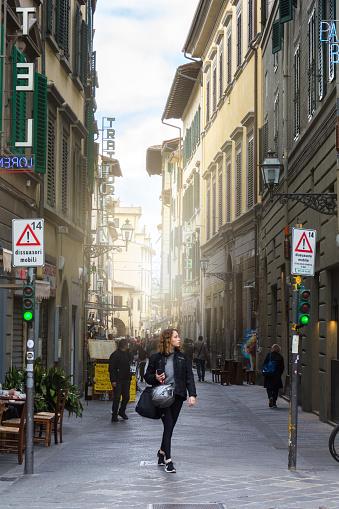 Florence, Italy - MAY 13,2019: Tourists walk through the picturesque streets of Florence on a bright sunny day