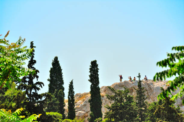 Tourists with cameras on Areospagos Hill(Hill of Ares) in Athens, Greece. The Areopagus is a prominent rock outcropping located northwest of the Acropolis in Athens. In the past, it was the court that tried cases involving murder, injury, arson, religious issues and olive trees. ares god of war stock pictures, royalty-free photos & images