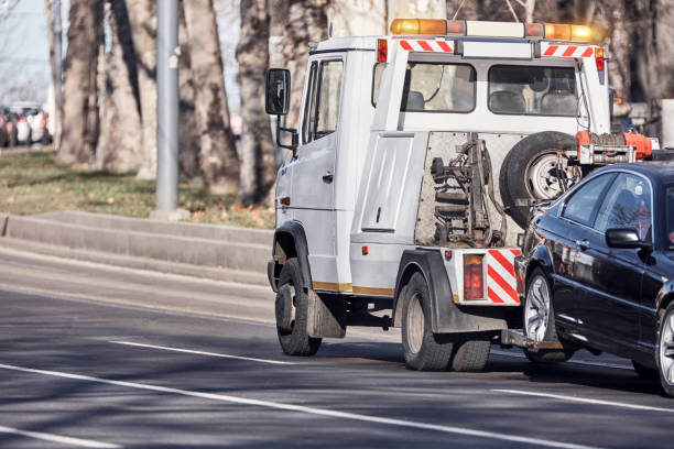 Tow truck carrying improperly parked car or repossesed vehicle. stock photo