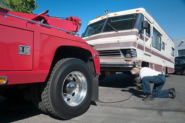 Tow Truck Driver Working on Broken Down Motor Home stock photo