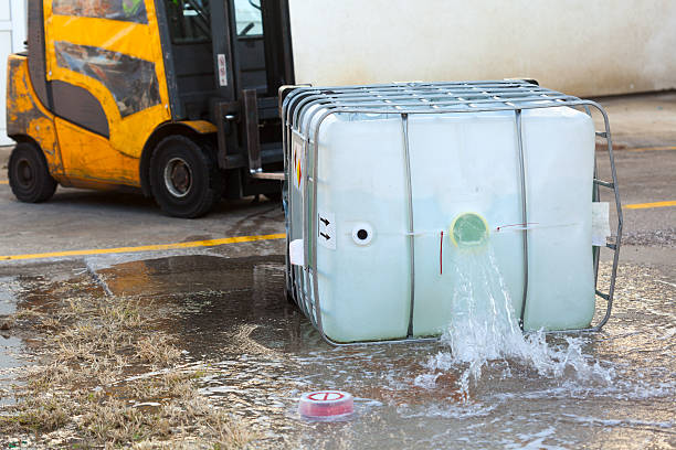 tow truck spilling dangerous goods from container - chemische stof stockfoto's en -beelden