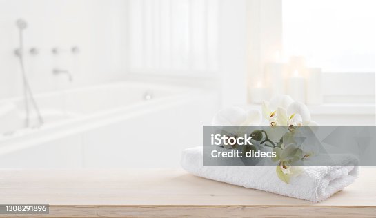 istock Towel and orchid flowers on wooden table with copy space 1308291896