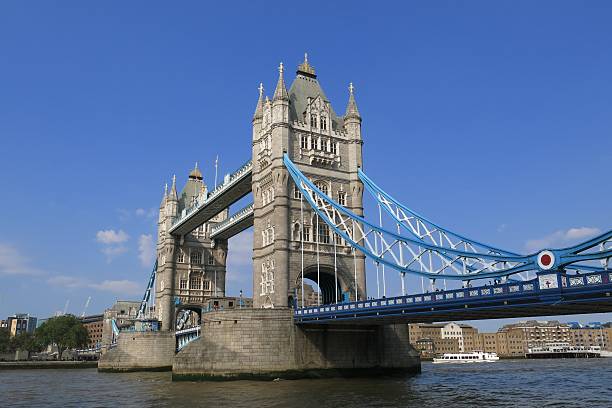 Tower Bridge, London, over Thames River bright blue sky day stock photo