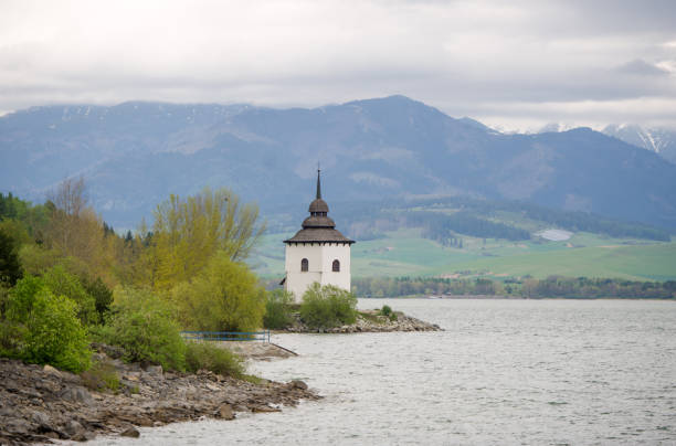 torre de la iglesia de la virgen maría en la orilla de la reserva del agua liptovska mara. eslovaquia. - mary mara fotografías e imágenes de stock