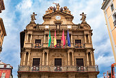 17th century Townhall or Ayuntamiento with flags on the facade on Plaza Consistorial in old town Pamplona, Spain famous for running of the bulls