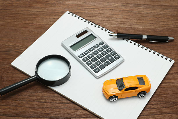 Toy car, magnifying glass, calculator, pen and notebook. +++NOTE TO INSPECTOR: THE ITEMS USED IN THIS IMAGE ARE GENERIC AND PURCHASED AT A DISCOUNT SHOP+++ car loan stock pictures, royalty-free photos & images