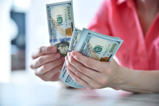 Trader woman hands counting US dollars cash in office stock photo
