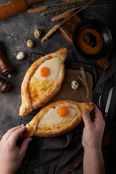 Traditional Adjarian khachapuri pies with salted cheese and egg stock photo