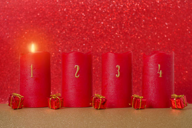 traditionelles advents-kerzen mit zahlen und geschenke auf rotem grund - erster advent stock-fotos und bilder