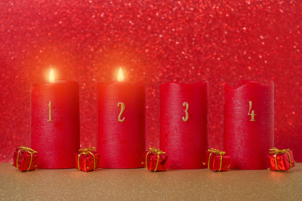 traditionelles advents-kerzen mit zahlen und geschenke auf rotem grund - erster advent stock-fotos und bilder