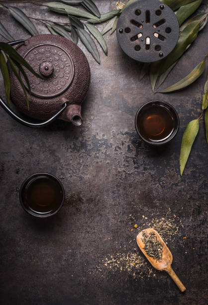 Traditional Asian green tea set with teapot and cups on dark rustic background stock photo