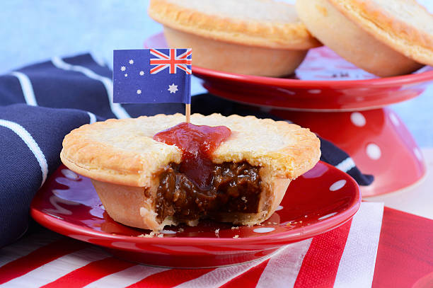 Traditional Australian Meat Pies Traditional Australian Meat Pies for Australia or Anzac Day holiday party food, in red, white and blue setting. meat pie stock pictures, royalty-free photos & images