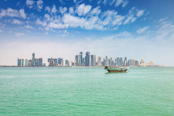 Traditional Dhow Modern Doha Skyline Qatar Traditional Dhow Boat on turquoise green water in front of Doha Skyscraper Skyline Bay. Doha, Qatar, Middle East. dhow stock pictures, royalty-free photos & images