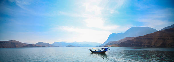 Traditional Dhow on the gulf A traditional dhow can be seen moving across the Persian Gulf in the Musandam, Oman.  oman stock pictures, royalty-free photos & images