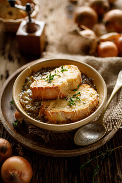 Traditional French onion soup baked with cheese croutons stock photo