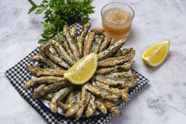 Traditional fried anchovies with lemon and parsley stock photo