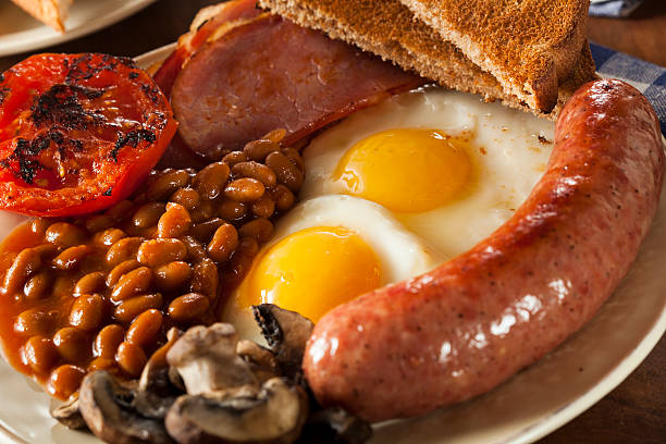 Traditional Full English Breakfast Traditional Full English Breakfast with Eggs, Bacon, Sausage, and Baked Beans full stock pictures, royalty-free photos & images