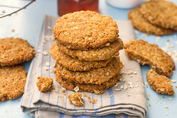 Traditional homemade Anzac biscuits with oats and coconut Traditional homemade Anzac biscuits with rolled oats and coconut  oats cookies stock pictures, royalty-free photos & images