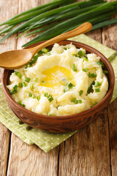 Traditional Irish champ is an easy side dish made with potatoes and green onions close up in the bowl. Vertical stock photo