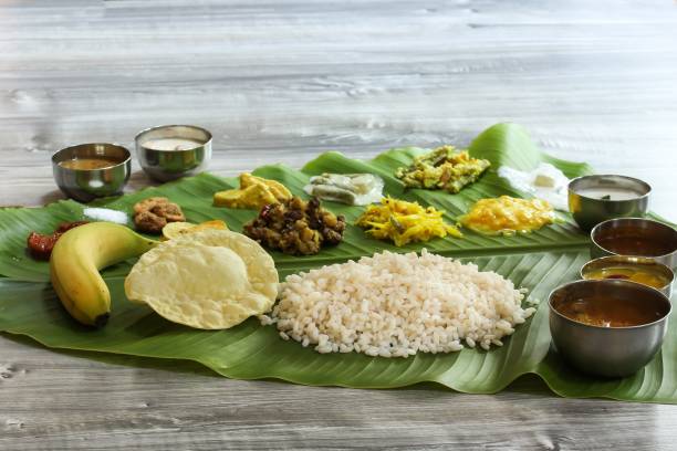 Traditional Kerala Onam Sadya   served in Banana Leaf / Vegetarian meal boiled rice curries and Papad served during festival stock photo