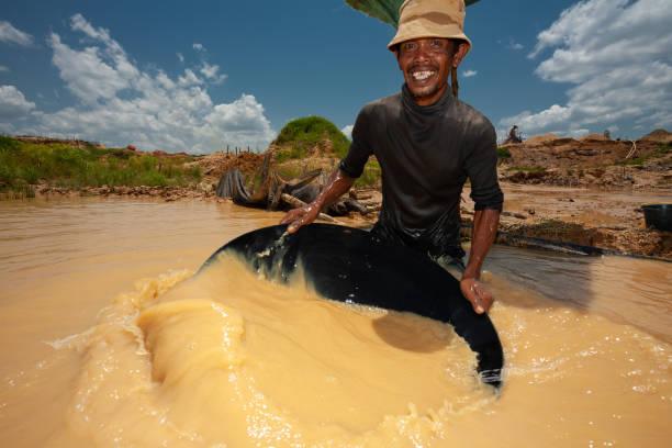 A traditional miner is smiling while shaking his panning tray stock photo